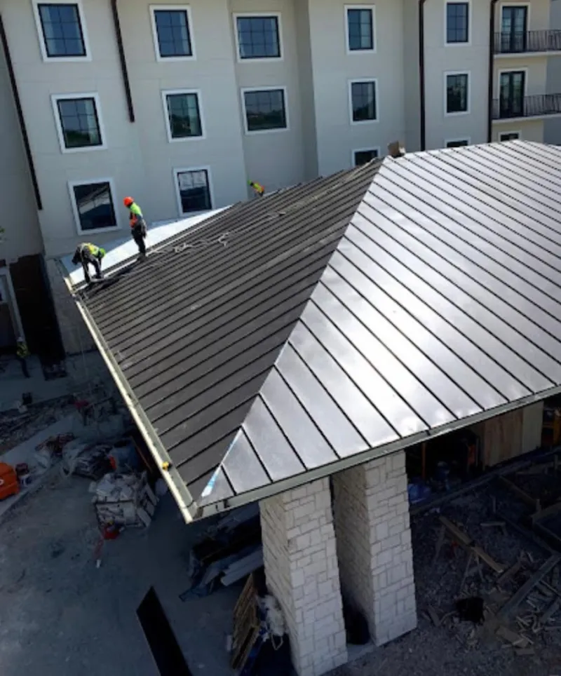 Crew installing standing seam metal roof panels on a commercial project in Port Wentworth